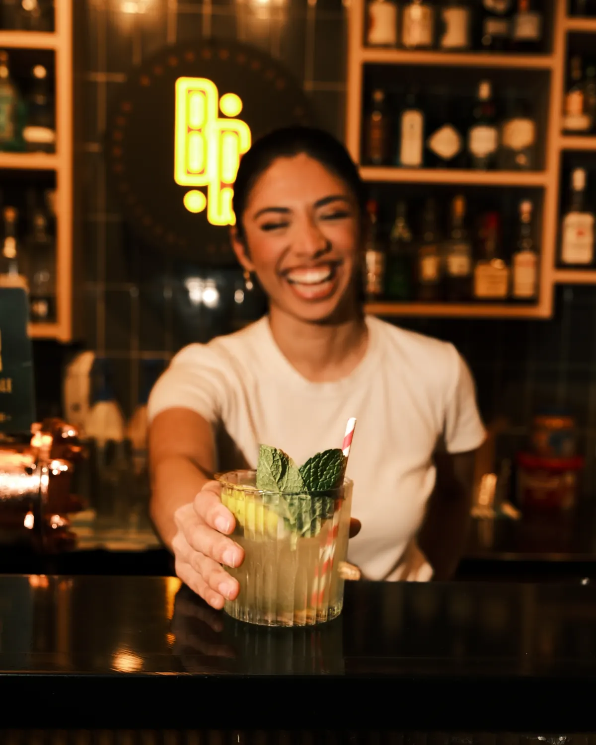 A bartender finishing a cocktail at the bar