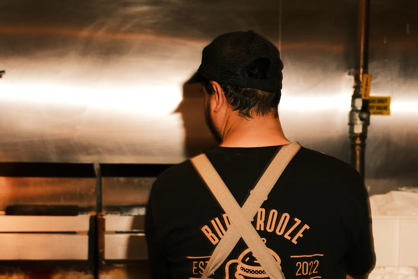 A Burgerooze cook working the pass during service